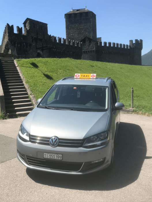 Un'auto swiss taxi parcheggiata davanti a delle mura storiche