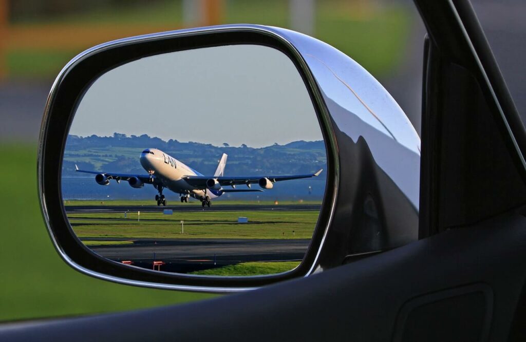 un aereo riflesso nello specchietto di taxi castione